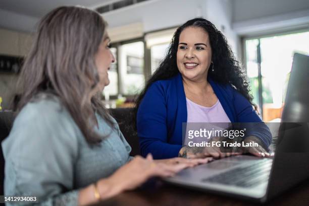 financial advisor doing a meeting with a senior woman at home - rent assistance stock pictures, royalty-free photos & images