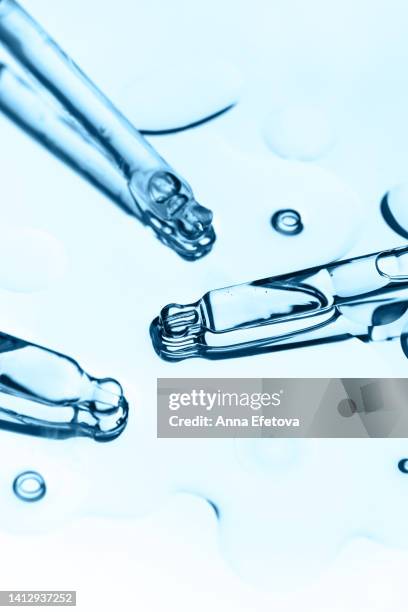 three glass pipettes with liquid with baubles. care cosmetics with peptides, ceramides, retinol molecules concept. oil or hyaluronic or polyglutamic acid - blood serum stock pictures, royalty-free photos & images