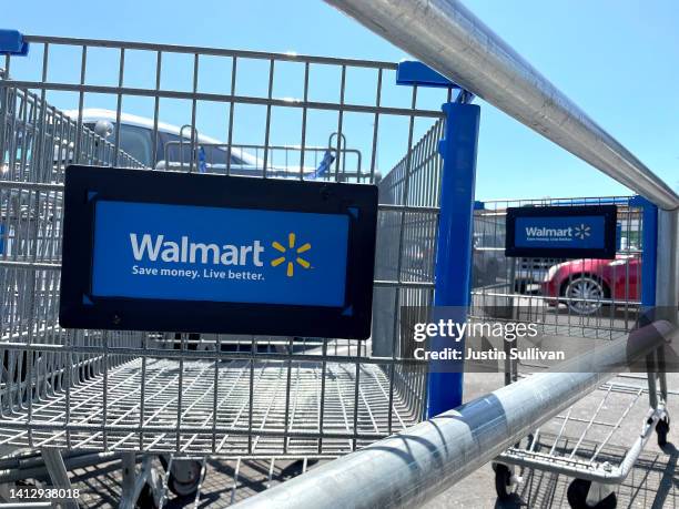 Shopping carts sit in the parking lot of a Walmart store on August 04, 2022 in Rohnert Park, California. Walmart plans to lay off hundreds of...