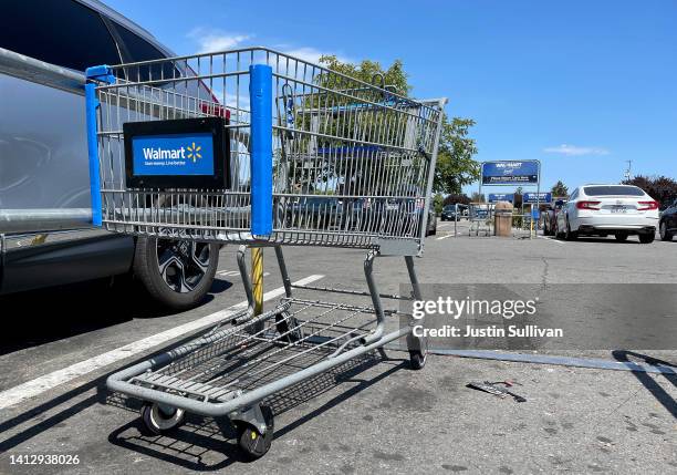 Shopping carts sit in the parking lot of a Walmart store on August 04, 2022 in Rohnert Park, California. Walmart plans to lay off hundreds of...