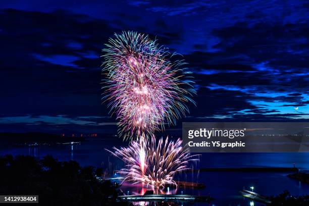 fireworks display in summer. japanese fireworks launched from the harbor. copy space. - 鳥取県 stockfoto's en -beelden