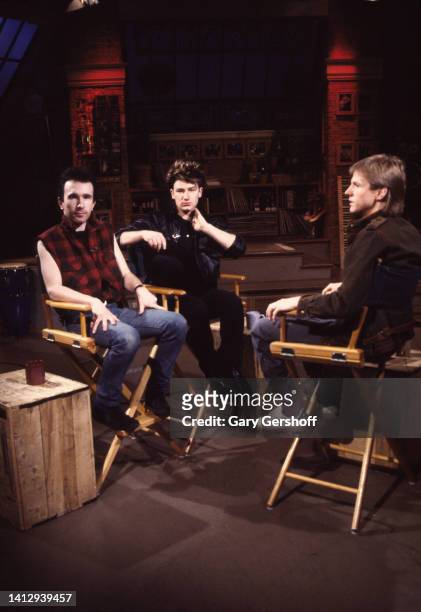 View, from left, of Rock musicians the Edge and Bono , both of the group U2, and MTV VJ Alan Hunter, as they sit in director's chairs during an...