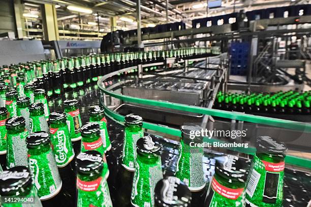 Bottles of lager move along a conveyor belt at the Carlsberg A/S production plant in Kiev, Ukraine, on Wednesday, March 14, 2012. Sales in the...