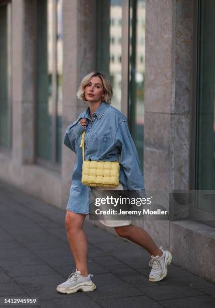 Franzi Koenig wearing beige Reserved shorts, a blue denim H&M shirt, white Balenciaga sneaker and a yellow Bottega Veneta bag on August 02, 2022 in...