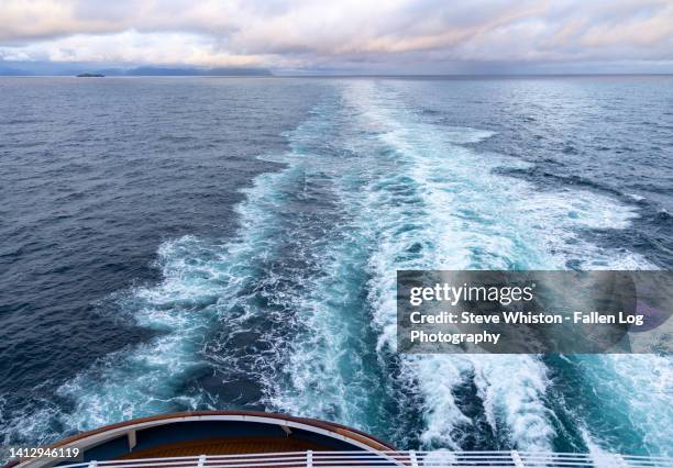view from back of cruise ship with ocean wake and distant clouds in horizon - cruise liner foto e immagini stock
