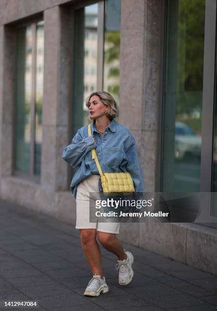 Franzi Koenig wearing beige Reserved shorts, a blue denim H&M shirt, white Balenciaga sneaker and a yellow Bottega Veneta bag on August 02, 2022 in...