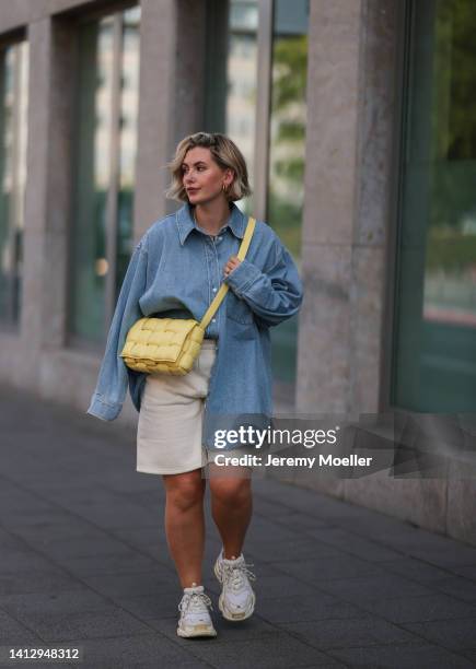 Franzi Koenig wearing beige Reserved shorts, a blue denim H&M shirt, white Balenciaga sneaker and a yellow Bottega Veneta bag on August 02, 2022 in...