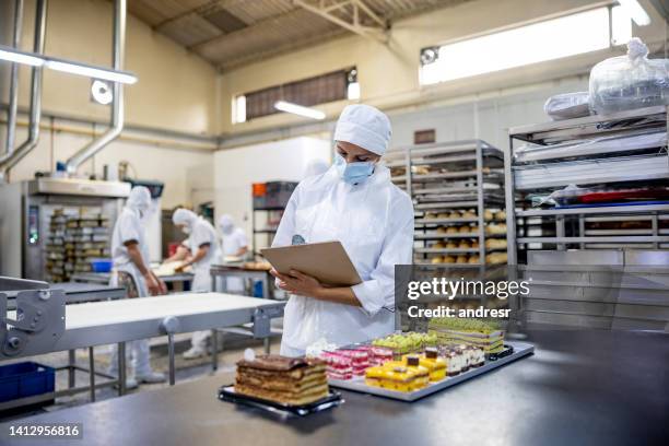 woman working at an industrial bakery and doing quality on some desserts - food production stock pictures, royalty-free photos & images