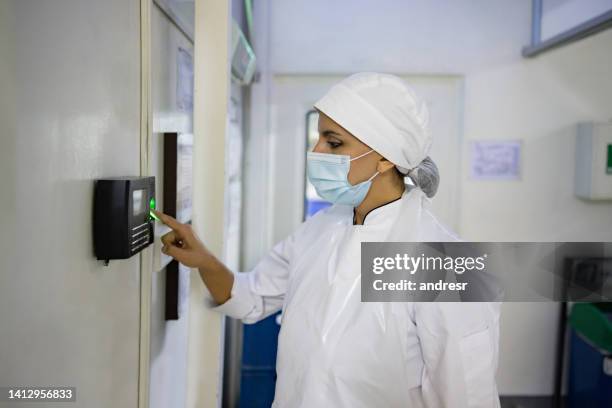 femme travaillant dans une usine de transformation des aliments et ouvrant une porte avec son empreinte digitale - réfrigérateur fermé photos et images de collection