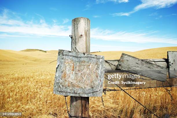 wooden post, wheat abundant landscape - wooden sign post stockfoto's en -beelden