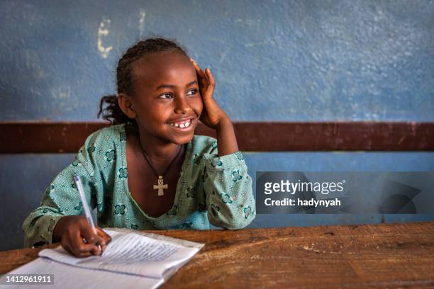 afrikanisches kleines mädchen lernt englisch - schwarz ethnischer begriff stock-fotos und bilder