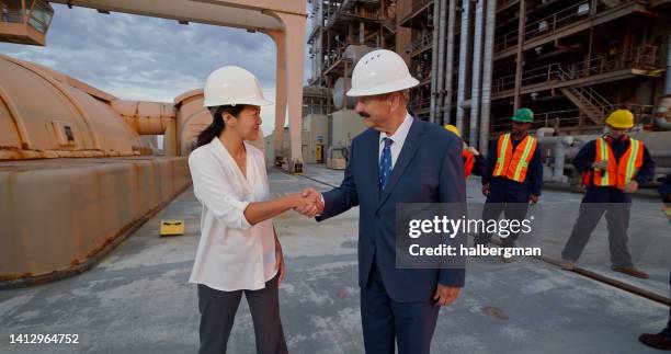 managers or politicians shaking hands outside power plant - female politicans stock pictures, royalty-free photos & images