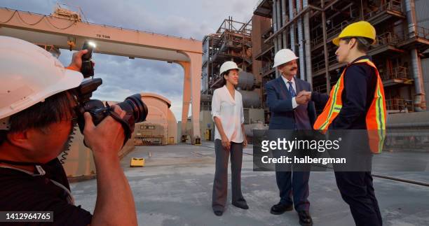 fotograf fotografiert manager oder politiker, die arbeitern die hand schütteln - bildjournalist stock-fotos und bilder