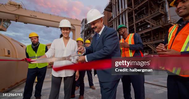 politicians and managers cutting ribbon at publicity event at power plant - black politician stock pictures, royalty-free photos & images