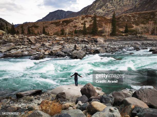 femme debout devant la rivière de montagne - montagnes altaï photos et images de collection