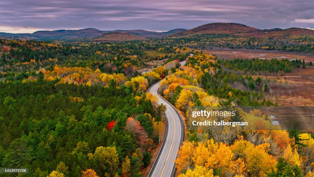 Luftaufnahme der Straße durch den Wald im Westen von Maine im Herbst