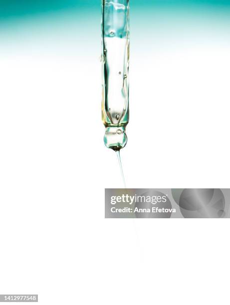 face serum with air bubbles is pouring from glass pipette on white background. concept of beauty procedures and body care. polyglutamic acid is a new hyaluronic acid. macro photography - organic chemistry in laboratory fotografías e imágenes de stock