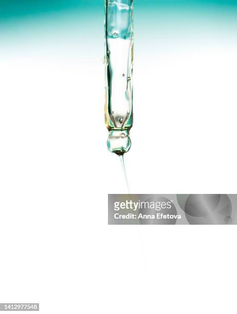 face serum with air bubbles is pouring from glass pipette on white background. concept of beauty procedures and body care. polyglutamic acid is a new hyaluronic acid. macro photography - oil macro stock pictures, royalty-free photos & images
