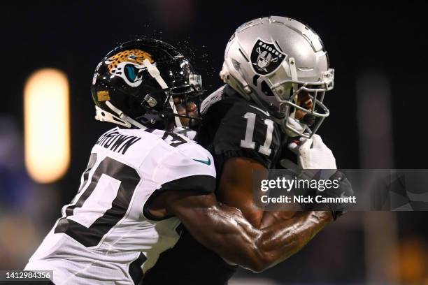 Demarcus Robinson of the Las Vegas Raiders catches a pass as he is hit by Montaric Brown of the Jacksonville Jaguars during the first half of the...