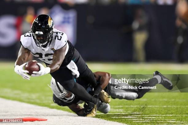 Josh Thompson of the Jacksonville Jaguars extends to convert a third down as he is forced out of bounds by Sam Webb of the Las Vegas Raiders during...