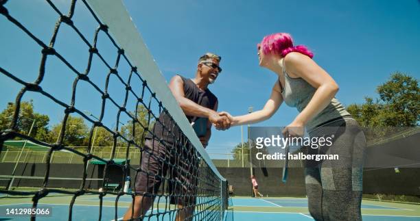 pickleball players shaking hands over the net - senior colored hair stock pictures, royalty-free photos & images