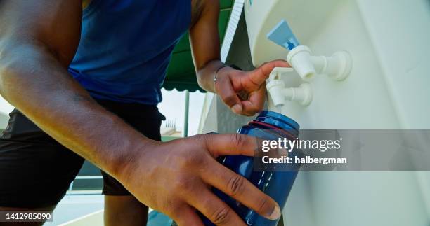 pickleball player llenando botella de agua - dispensador de agua fotografías e imágenes de stock