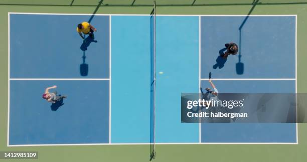 drone shot guardando dritto verso il basso sul gioco del doppio pickleball - paddle tennis foto e immagini stock