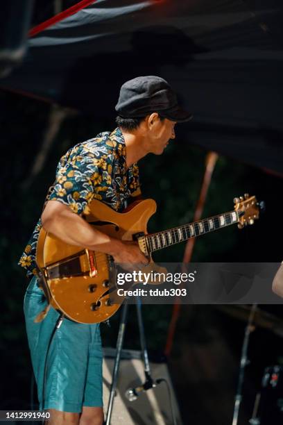 mittlerer erwachsener mann, der bei einem outdoor-musikfestival eine e-gitarre spielt - acoustic music stock-fotos und bilder