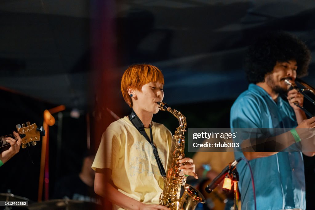 Frau, die bei einem Outdoor-Musikfestival Saxophon spielt