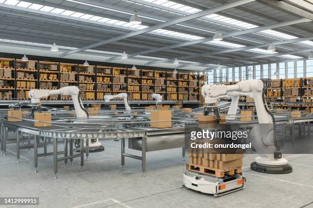 distribution warehouse with automated guided vehicles and robots working on conveyor belt - robot arm 個照片及圖片檔