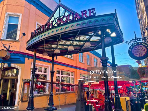 people dining under bastion square ceremonial arch/sign, victoria - victoria canada dining stock pictures, royalty-free photos & images
