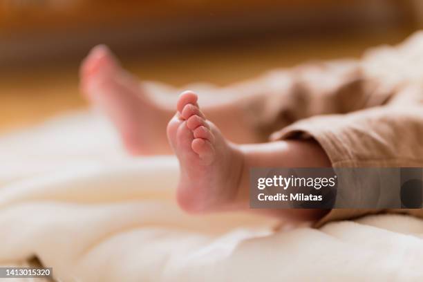 close-up of baby's feet lying down - barefoot feet up lying down girl stock-fotos und bilder