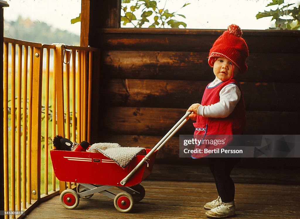 Toddler with red pram