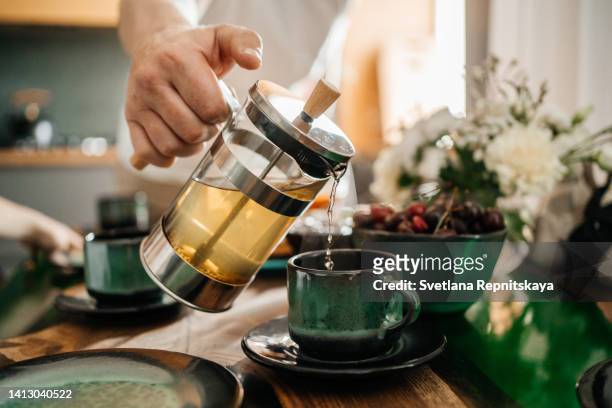 man pouring tea into a cup, close-up - man having tea stock pictures, royalty-free photos & images