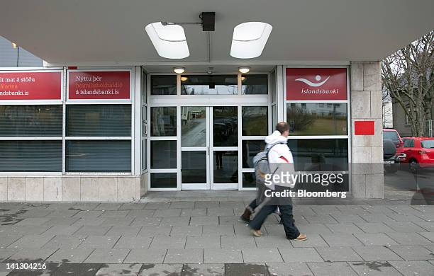 Pedestrians pass the entrance to an Islandsbanki HF bank branch in Reykjavik, Iceland, on Wednesday, March 14, 2012. Iceland pushed through stricter...