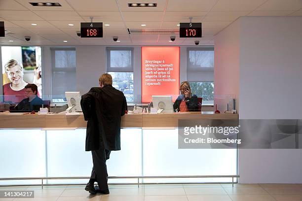 Employees attend to customers at a service desk inside the Islandsbanki HF headquarters in Reykjavik, Iceland, on Wednesday, March 14, 2012. Iceland...