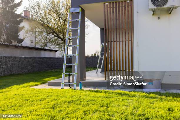 paint equipment and ladder outside apartment during sunny day - sunny backyard stock pictures, royalty-free photos & images