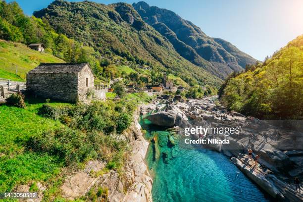 old stone roman bridge over clear clean green water, switzerland - ticino canton stock pictures, royalty-free photos & images