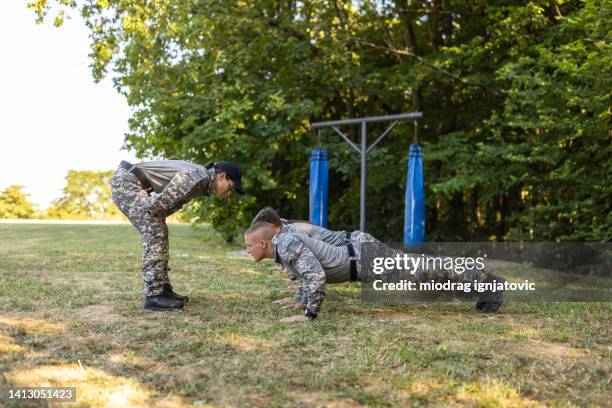 military team having an outdoor military training, leaded by the female sergeant - sergeant stock pictures, royalty-free photos & images