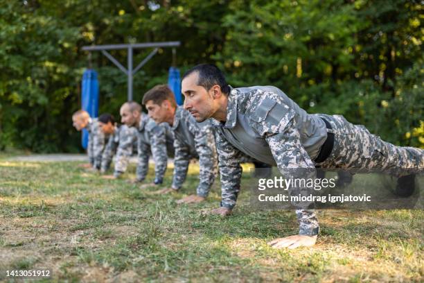 military team having an outdoor military training, while doing push ups - military training stock pictures, royalty-free photos & images