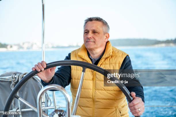 man steering a sailboat - ship captain stock pictures, royalty-free photos & images