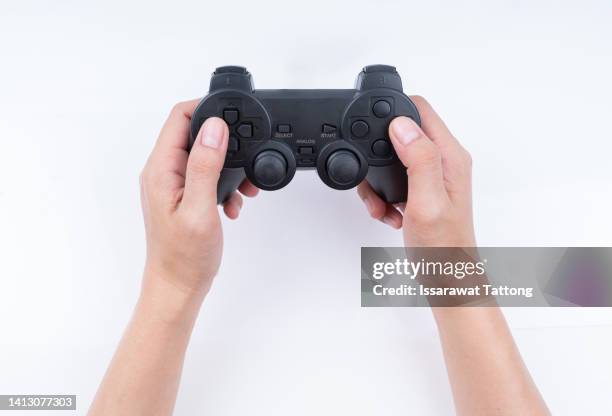 hand holding game controller isolated on white background - gamepad stock-fotos und bilder