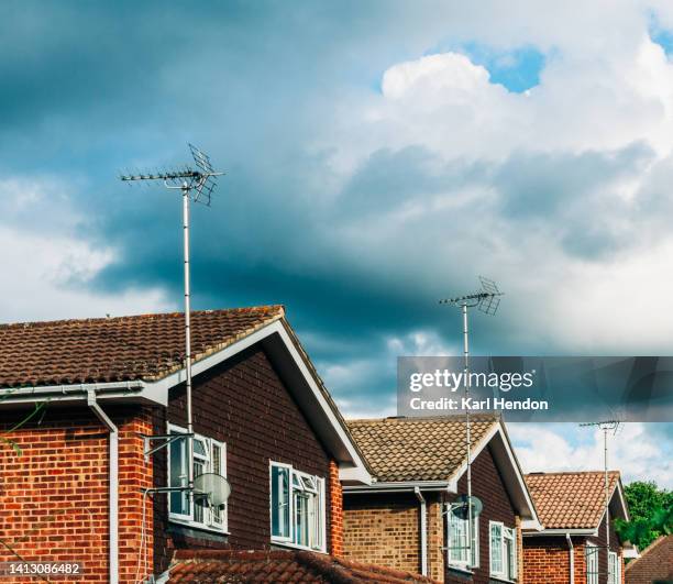 a view of suburban houses in surrey, uk - televisieantenne stockfoto's en -beelden