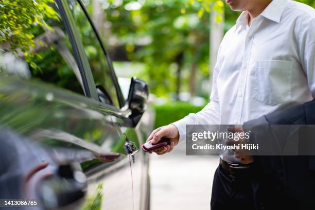 hand unlock the car door. keyless entry system on the modern car - auto tür offen stock-fotos und bilder