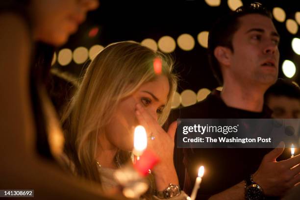 Carolina Fanning, of Potomac, MD, wipes tears away in a prayer circle as "Amazing Grace" is sung across the street from the Lululemon where Jayna...