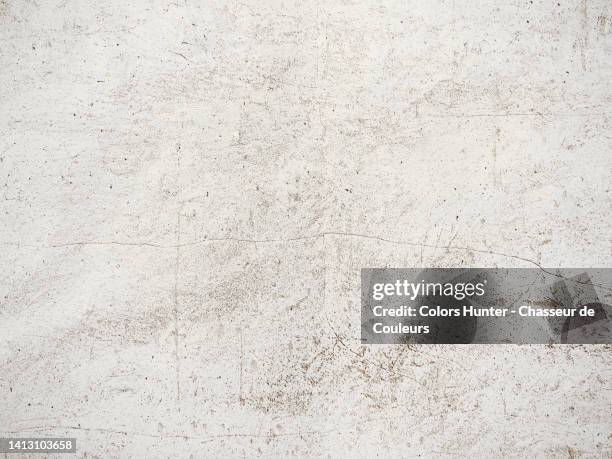 weathered and scratched white paint on a stone wall in paris, france - paint textures ストックフォトと画像