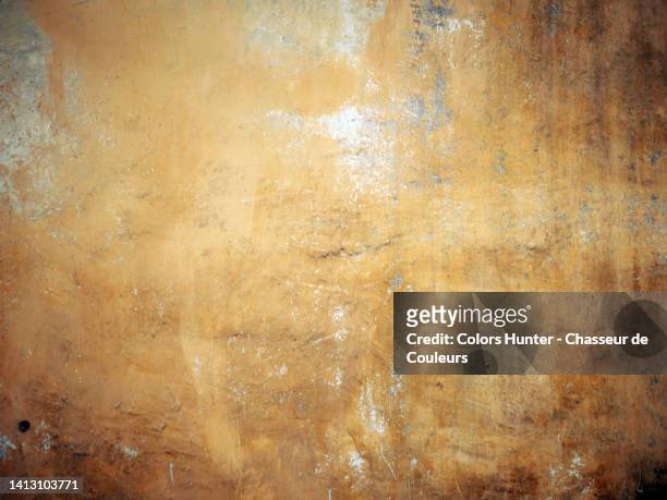 weathered and scratched yellow and brown paint on textured concrete wall in paris, france - patina 個照片及圖片檔