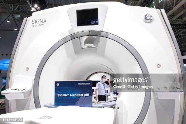 Exhibitors stand by medical equipment of General Electric during the 2022 World Health Expo held in Wuhan International Expo Center on August 5,2022...