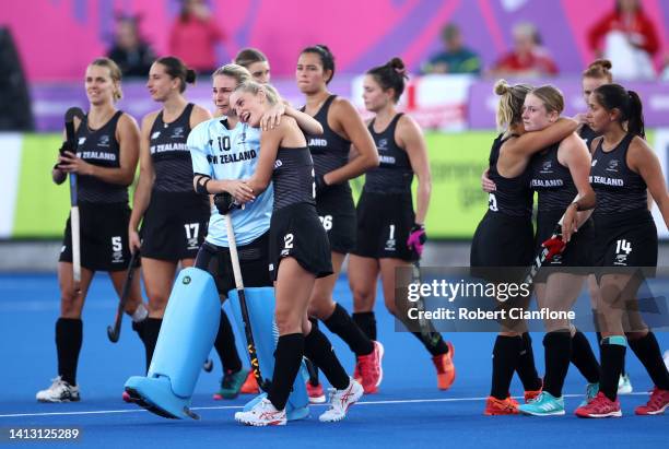 Katie Doar and Brooke Roberts of Team New Zealand look dejected with teammates following defeat in the Women 's Hockey Semi-Final match between Team...