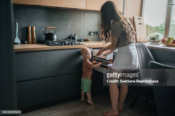 mom chooses products for the baby in the kitchen, proper nutrition - burner stove top stock pictures, royalty-free photos & images